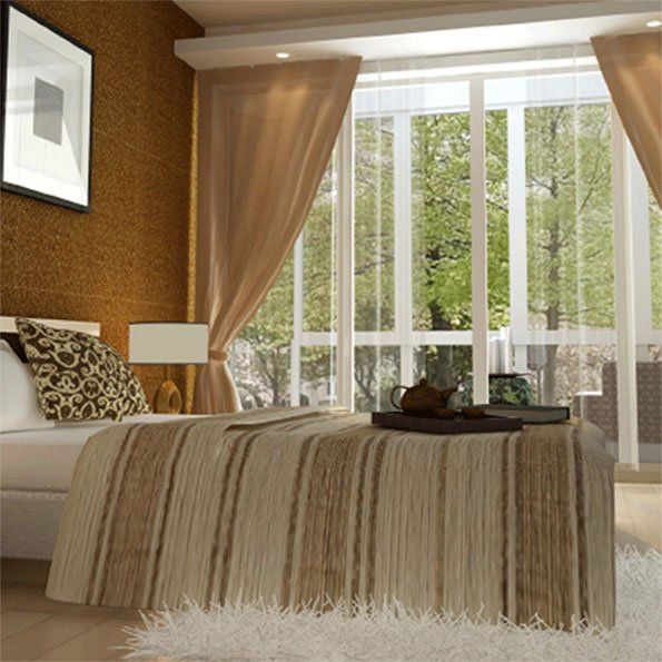 A bedroom with a striped blanket on the bed