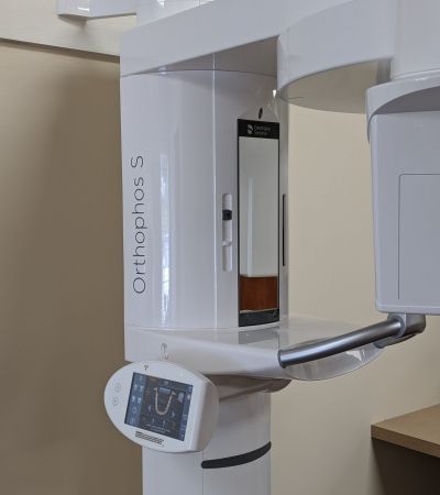 A white x-ray machine is sitting on top of a wooden table.