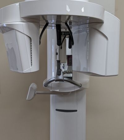 A dental x-ray machine is sitting on a table in a dental office.