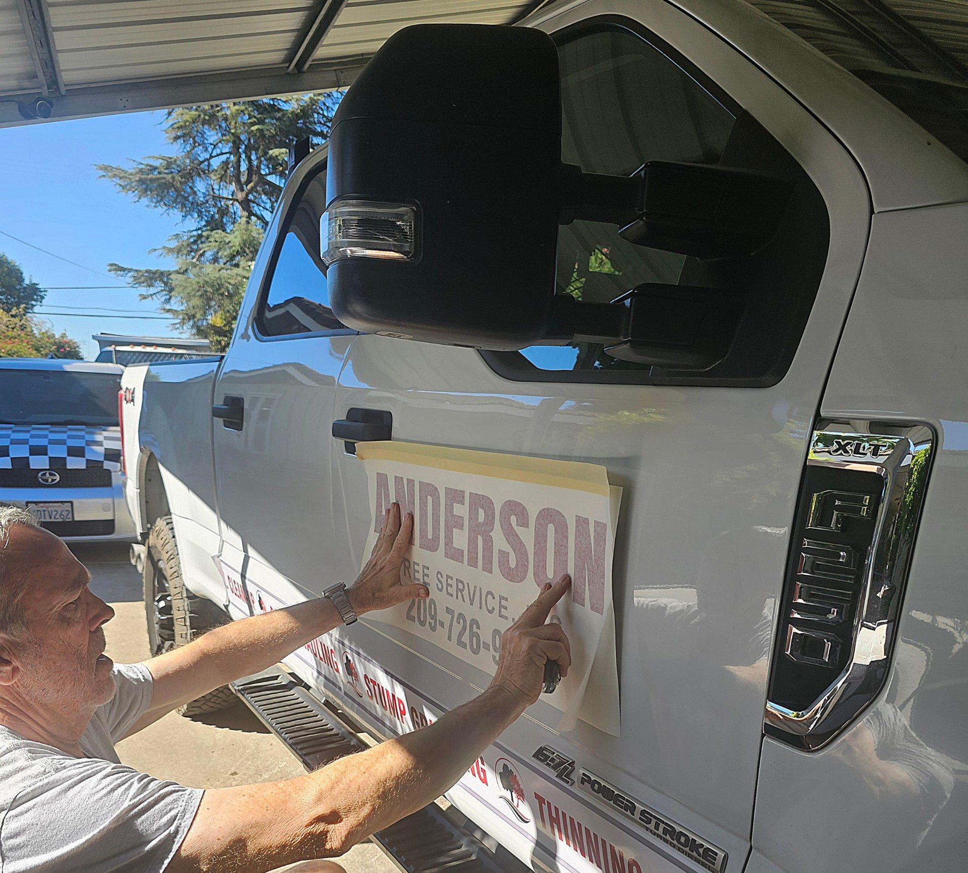 A man is pointing at a sign on the side of a truck.