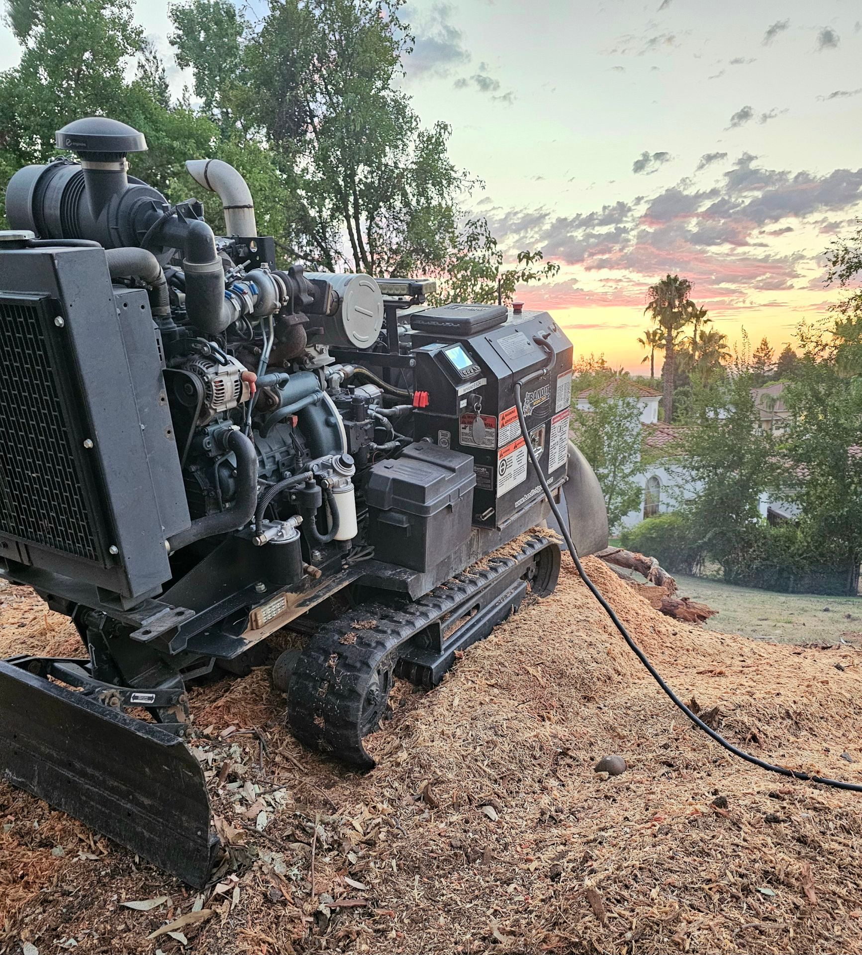 A large machine is sitting on top of a pile of wood chips.
