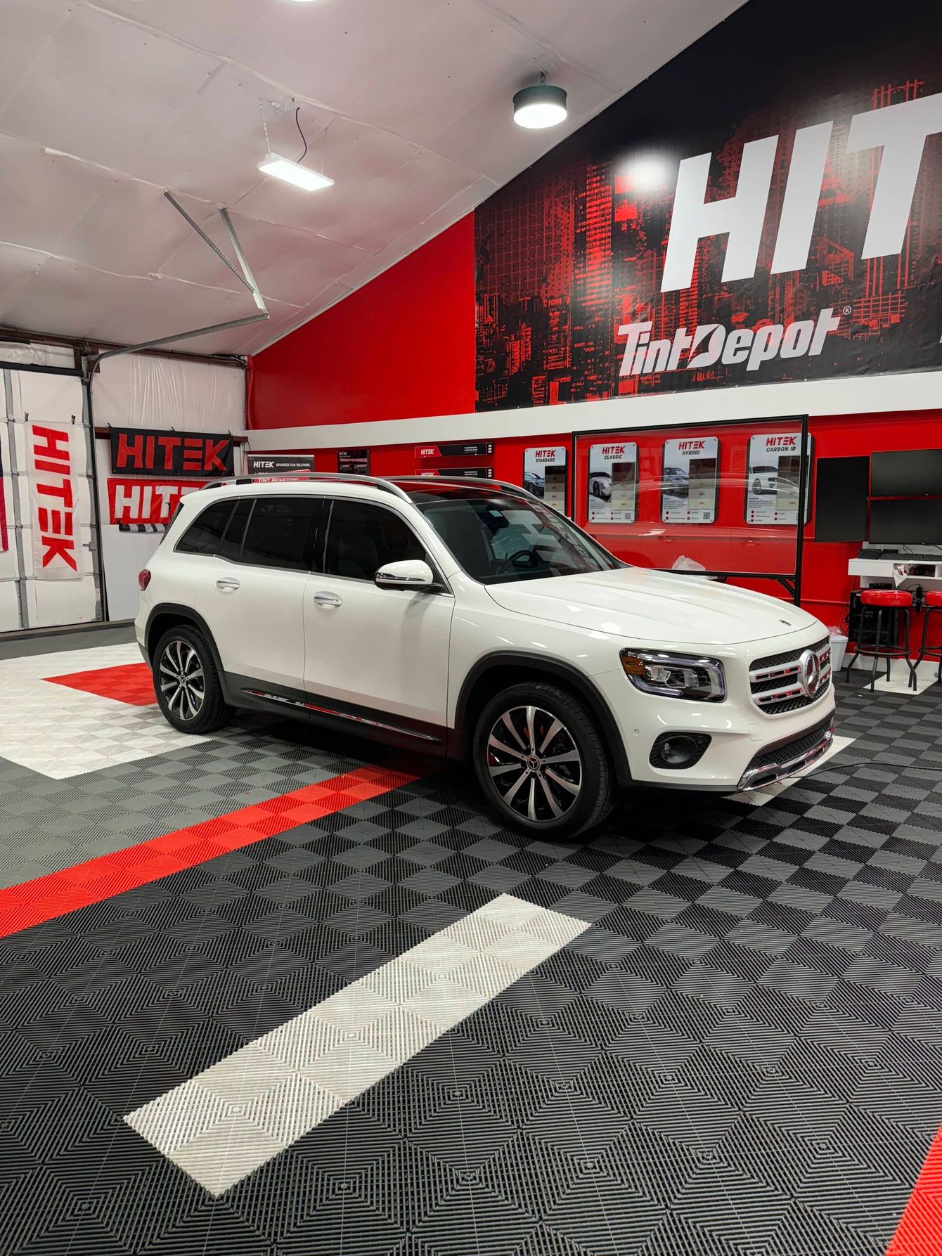 A white mercedes benz glb is parked in a garage.