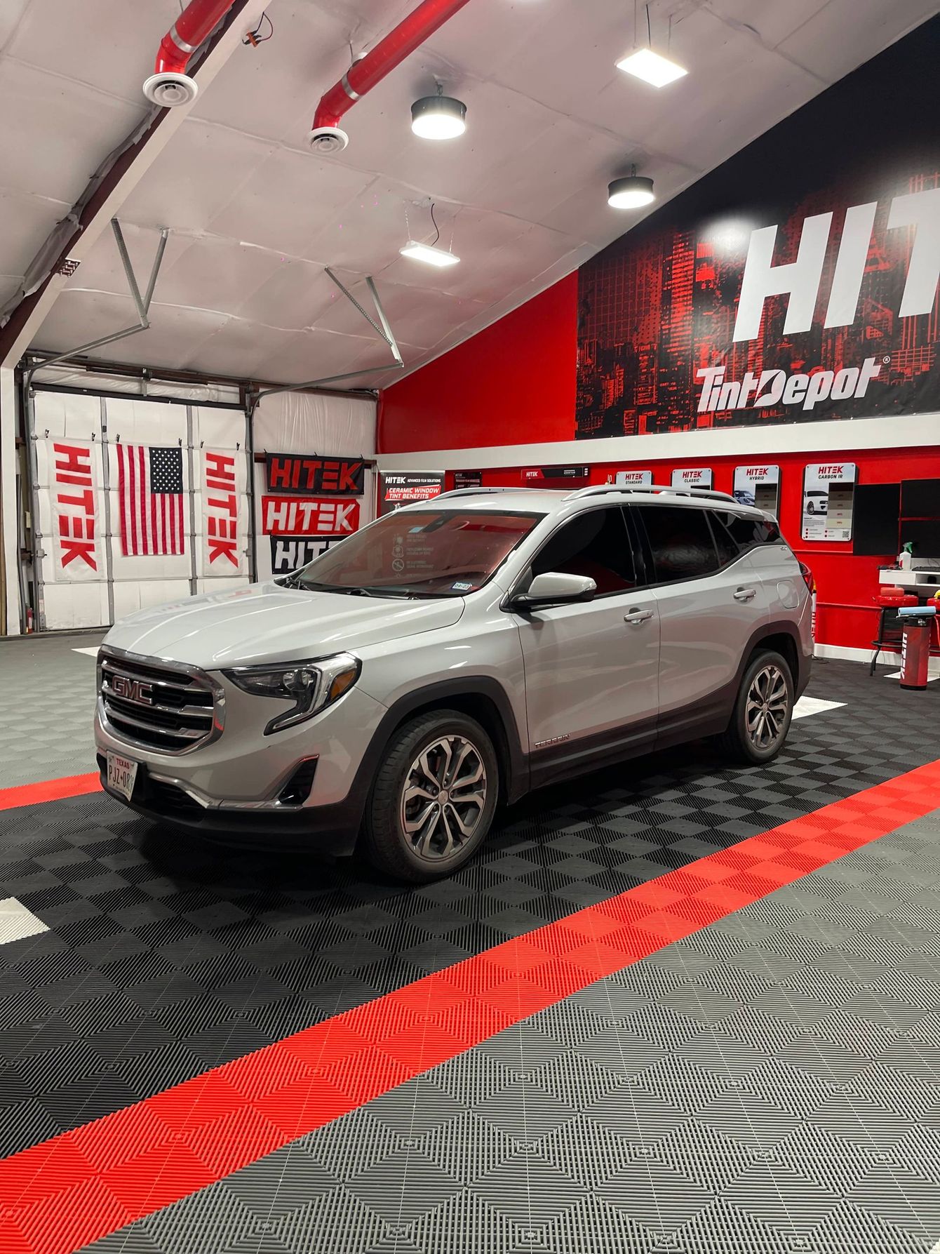 A silver car is parked in a garage.