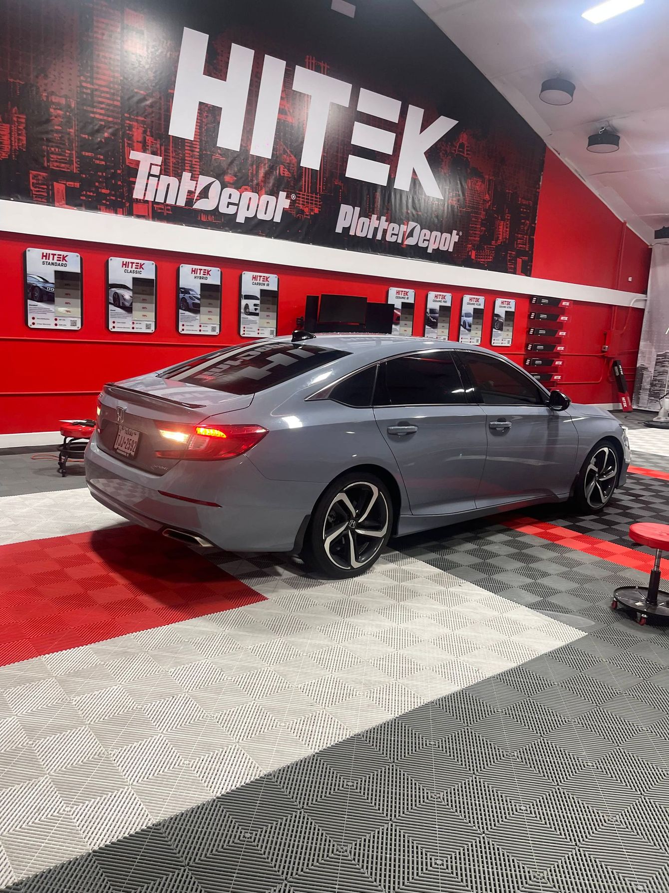 A gray honda accord is parked in a garage.