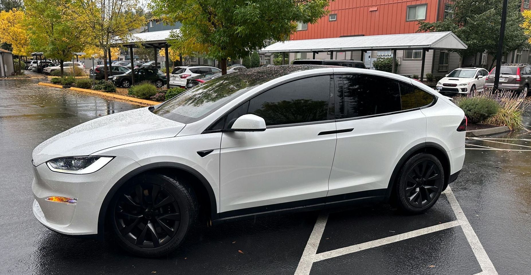 A white tesla model x with tinted windows, showcasing the stylish and protective benefits of automotive window tinting.