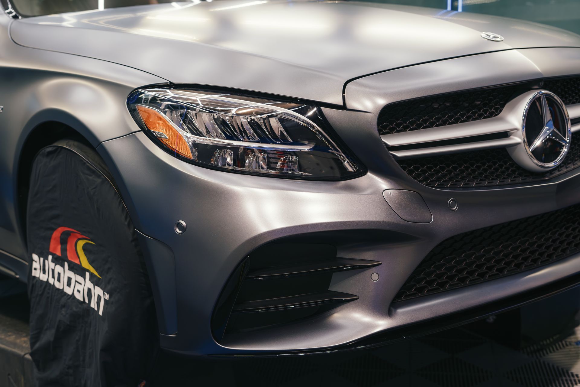 A close up of a mercedes with a tire cover on it