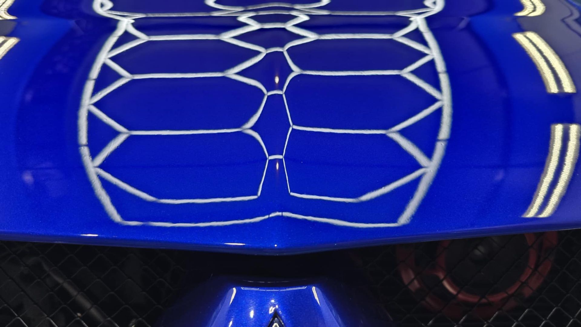 A blue car with a white design on the hood