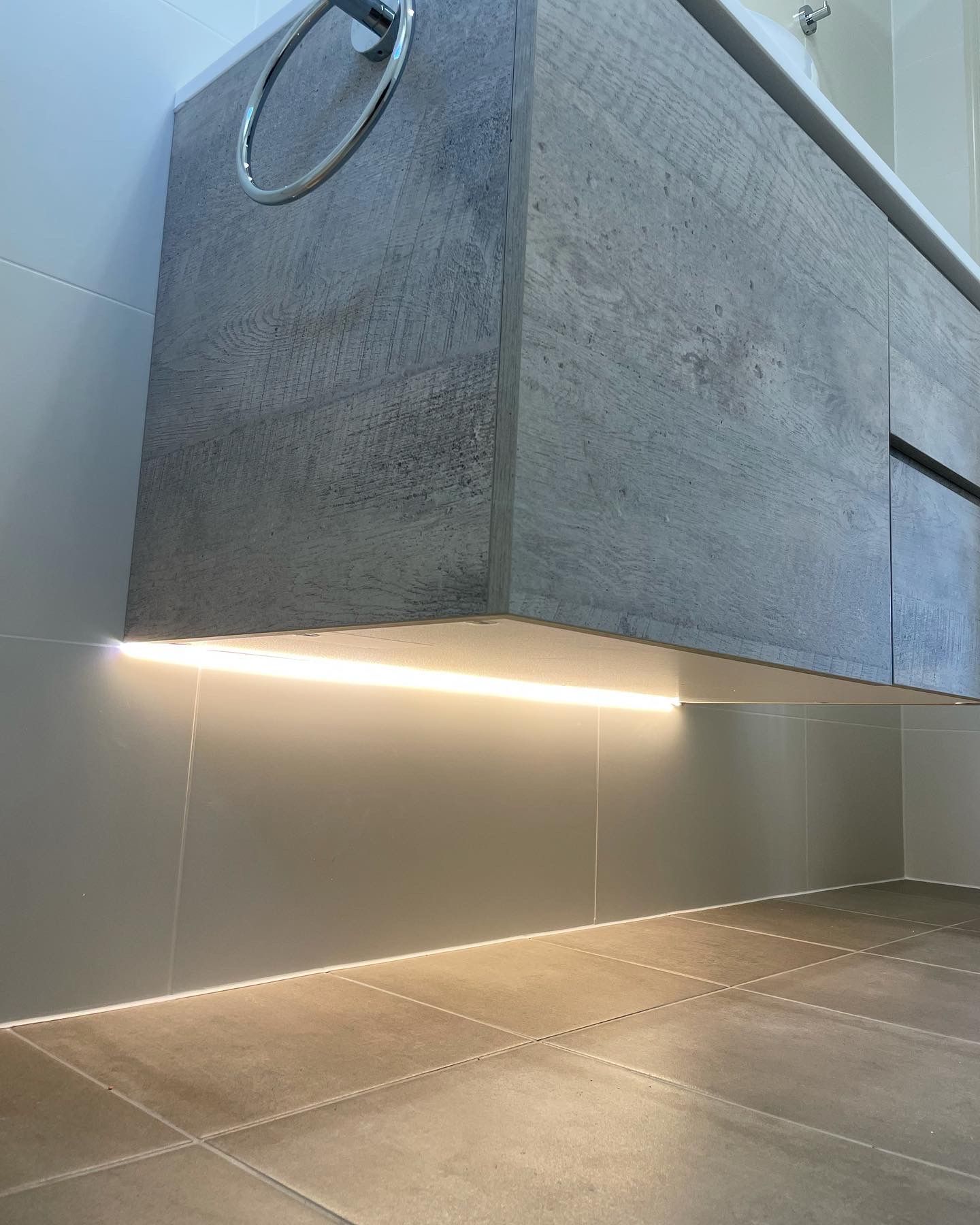 A Close Up Of An LED Light Under A Cabinet And Tiled Floors— TB Electrical & Communications in Kincumber, NSW