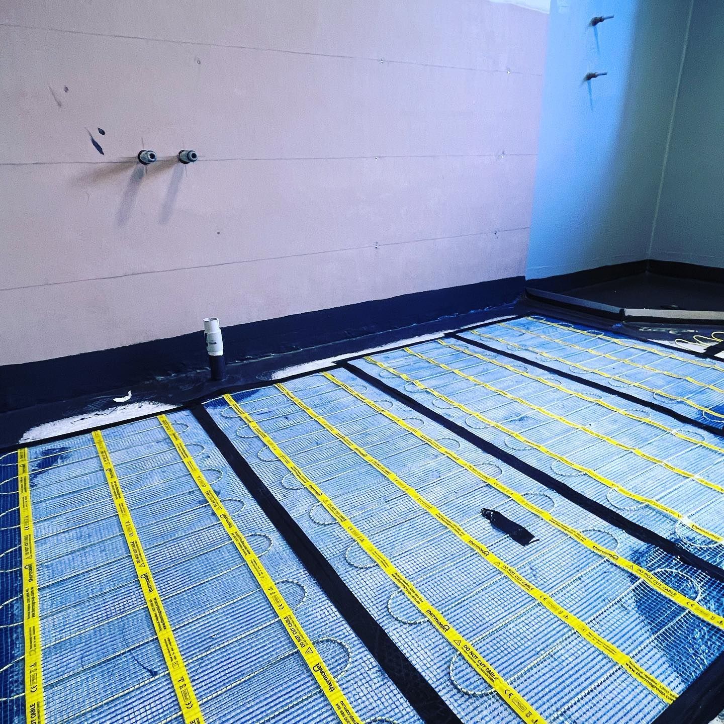 Skilled Electrician Installing Floor Heating Panels — TB Electrical & Communications in Erina, NSW