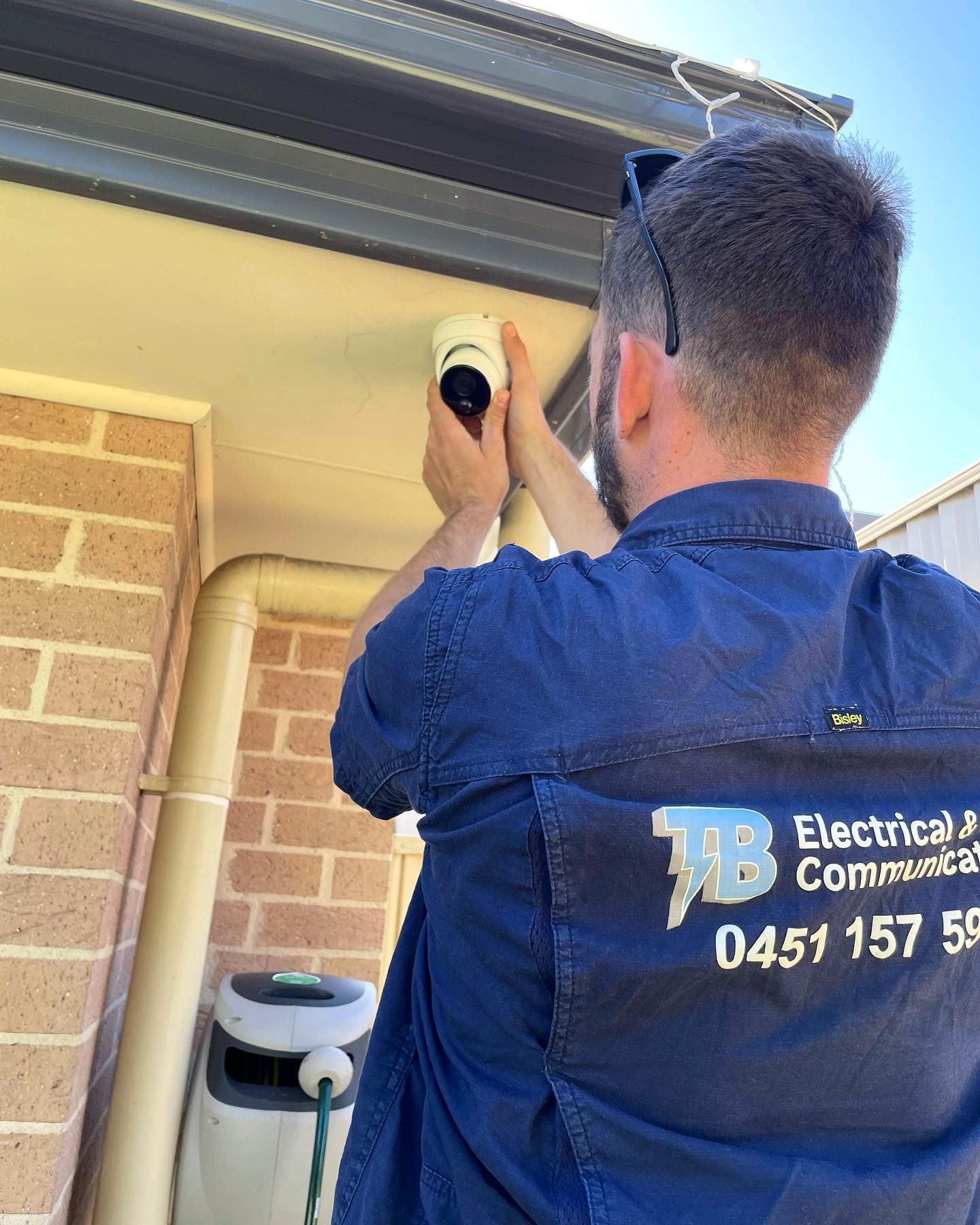 A Man Fixing A CCTV Camera — TB Electrical & Communications in Kincumber, NSW