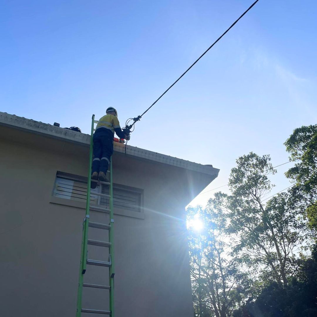 A Man Working On A Building — TB Electrical & Communications in Erina, NSW