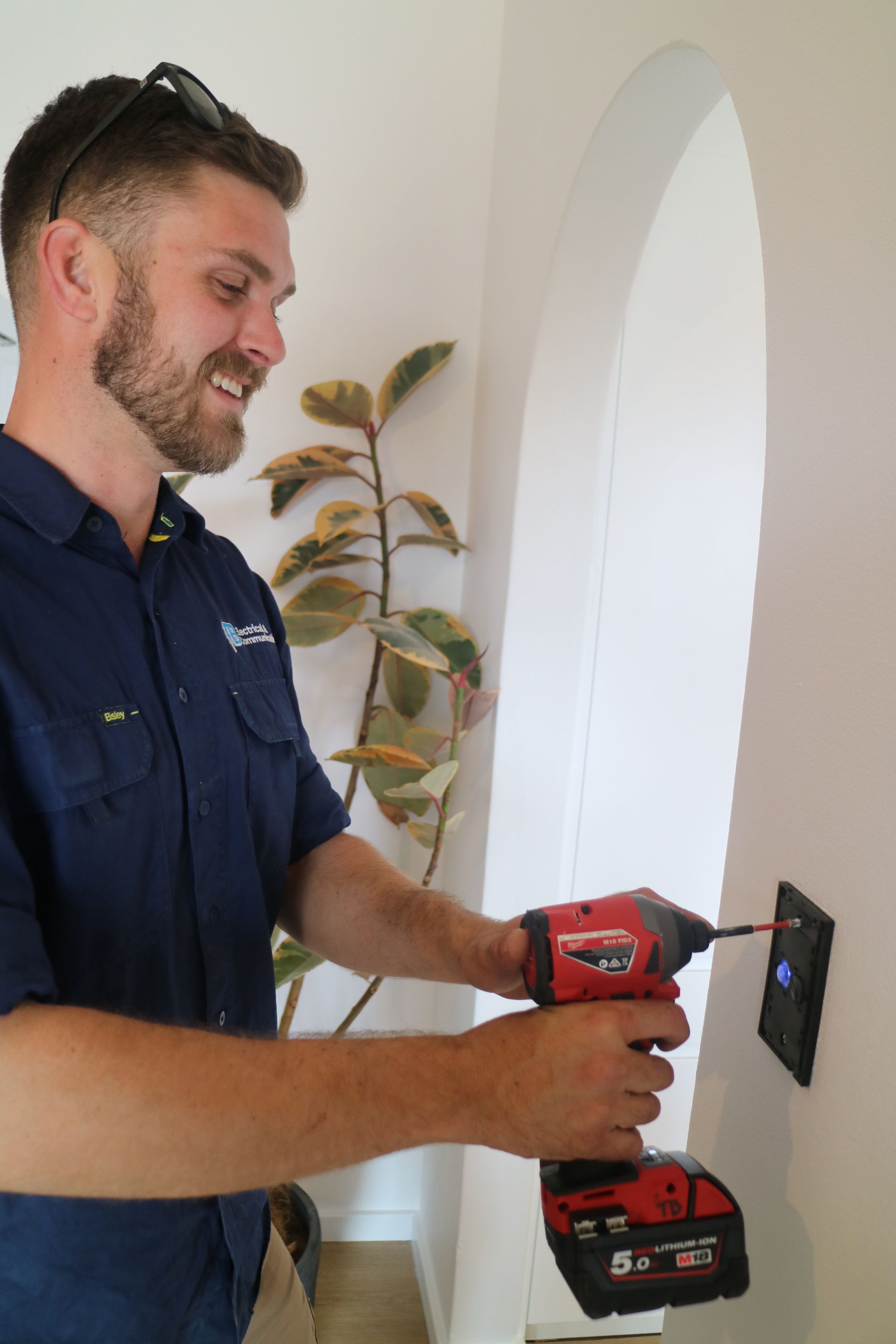 A Person is Fixing a Light switch — TB Electrical & Communications in Erina, NSW