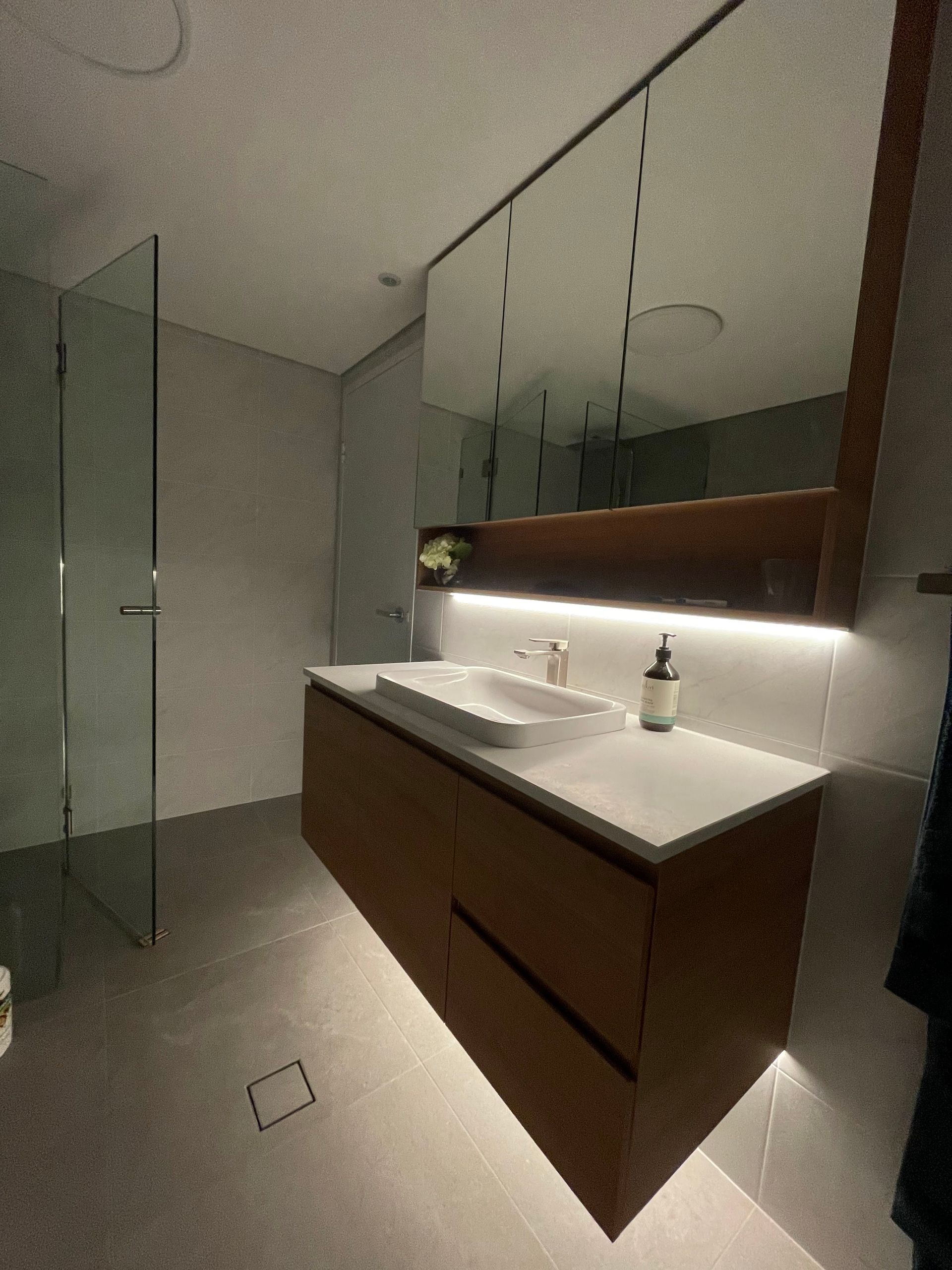 A Bathroom With LEDs Under The Mirror And Basin Cabinet — TB Electrical & Communications in Erina, NSW