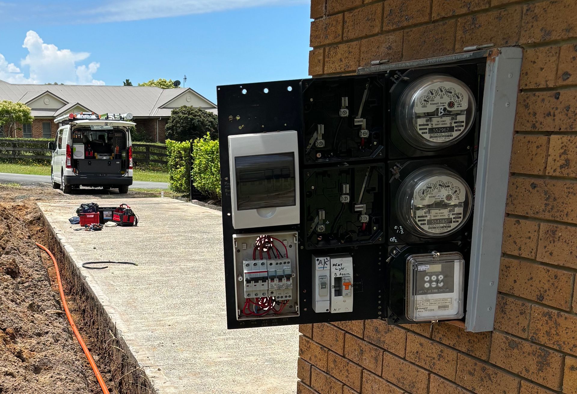 A Man is Working on an Electrical Panel With a Screwdriver — TB Electrical & Communications in Erina, NSW