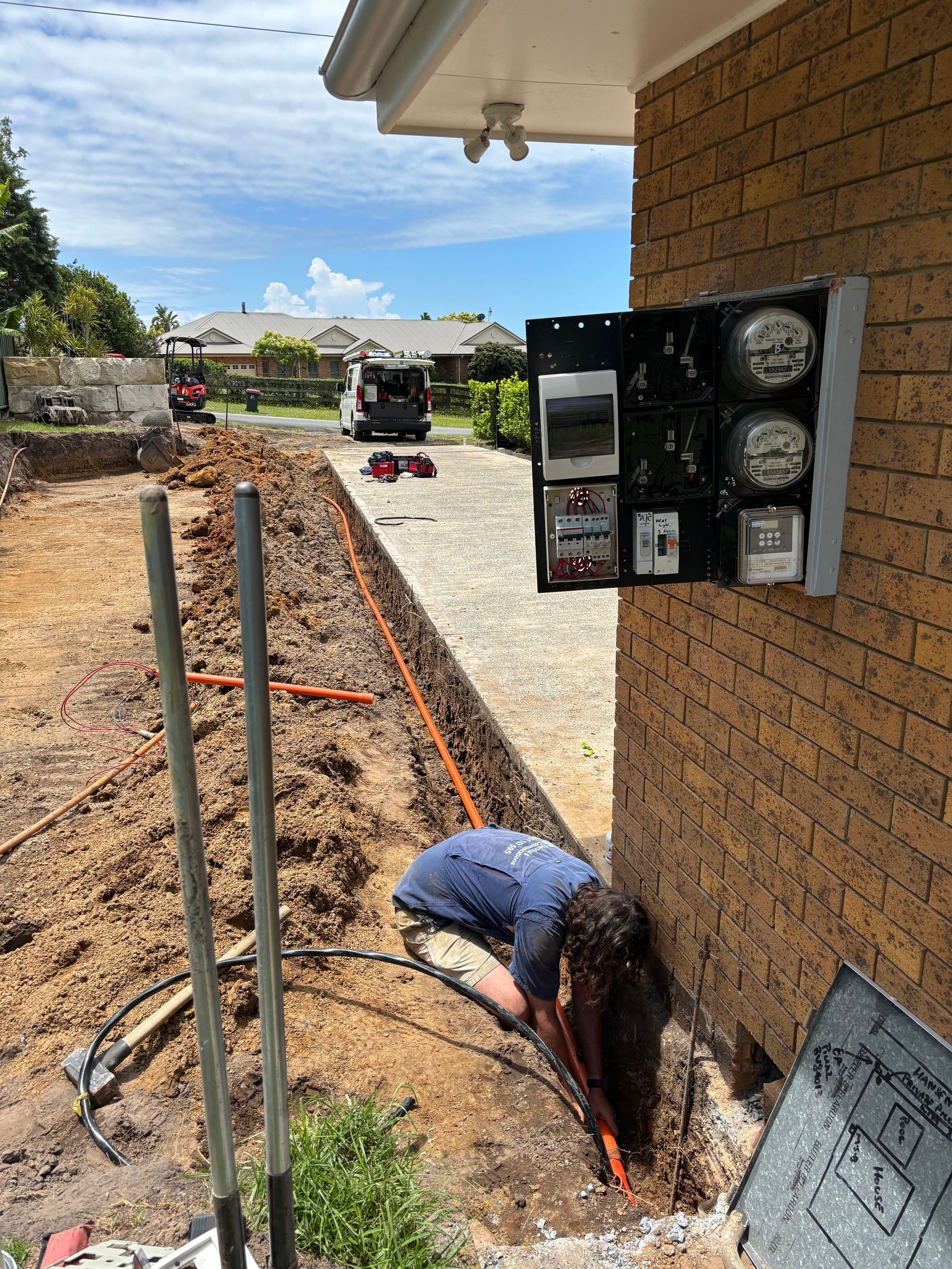 A Man Installing An Electrical Cable Underground — TB Electrical & Communications in Erina, NSW