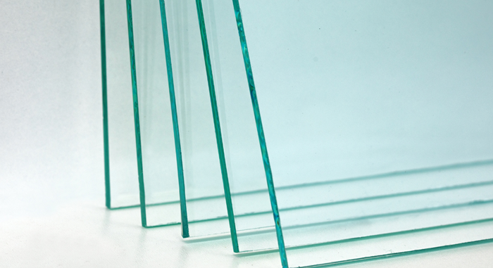 a row of clear glass sheets stacked on top of each other on a white surface .