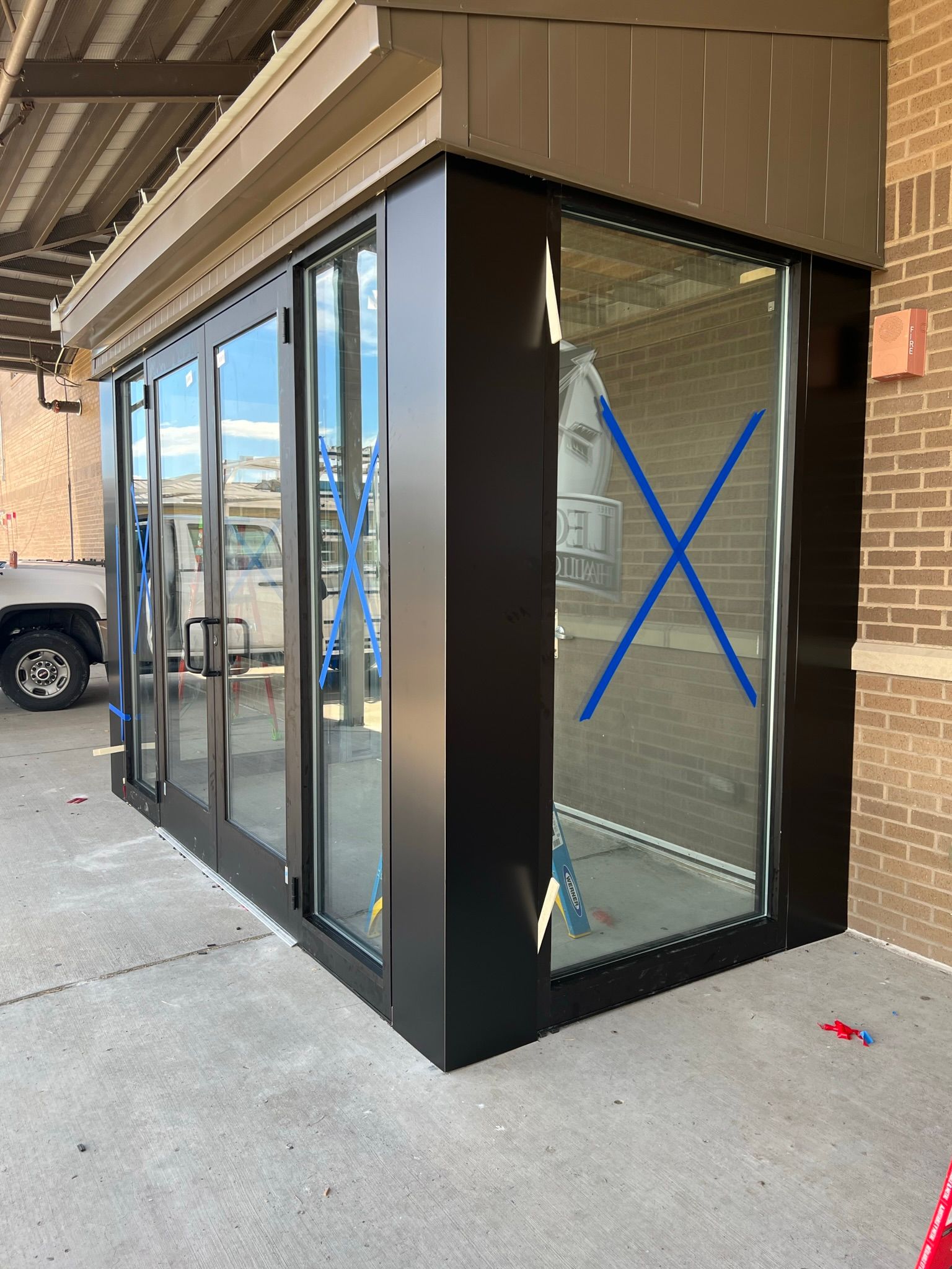 a building with a brick wall and a large glass door