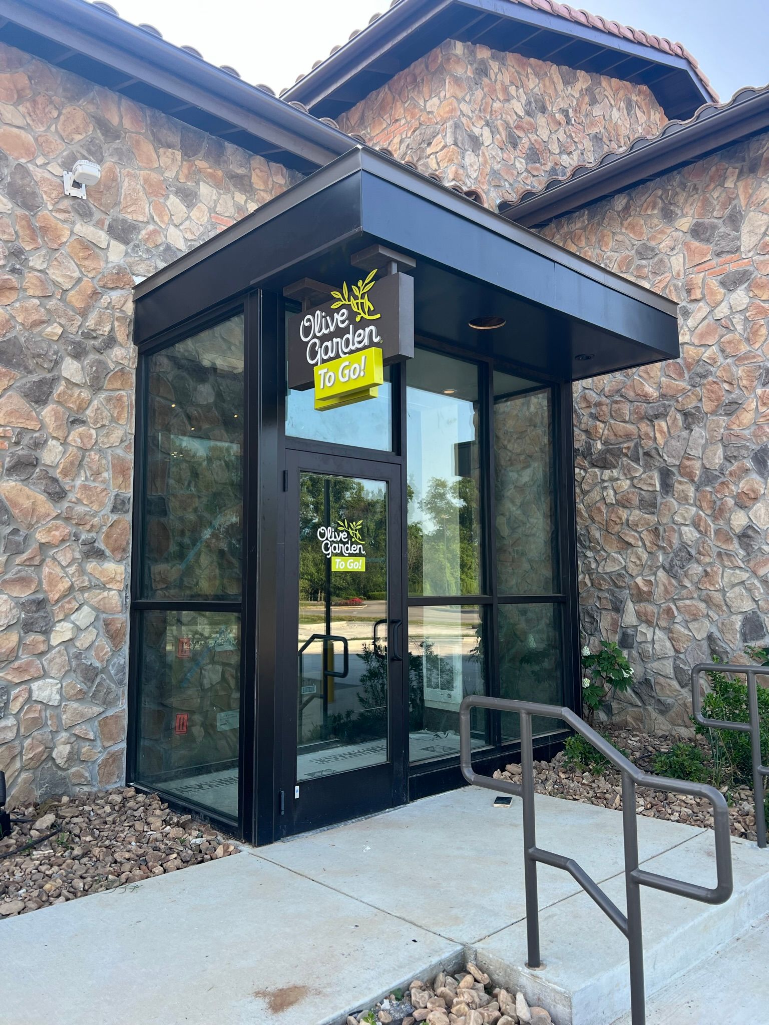a building with a sign that says olive garden to go