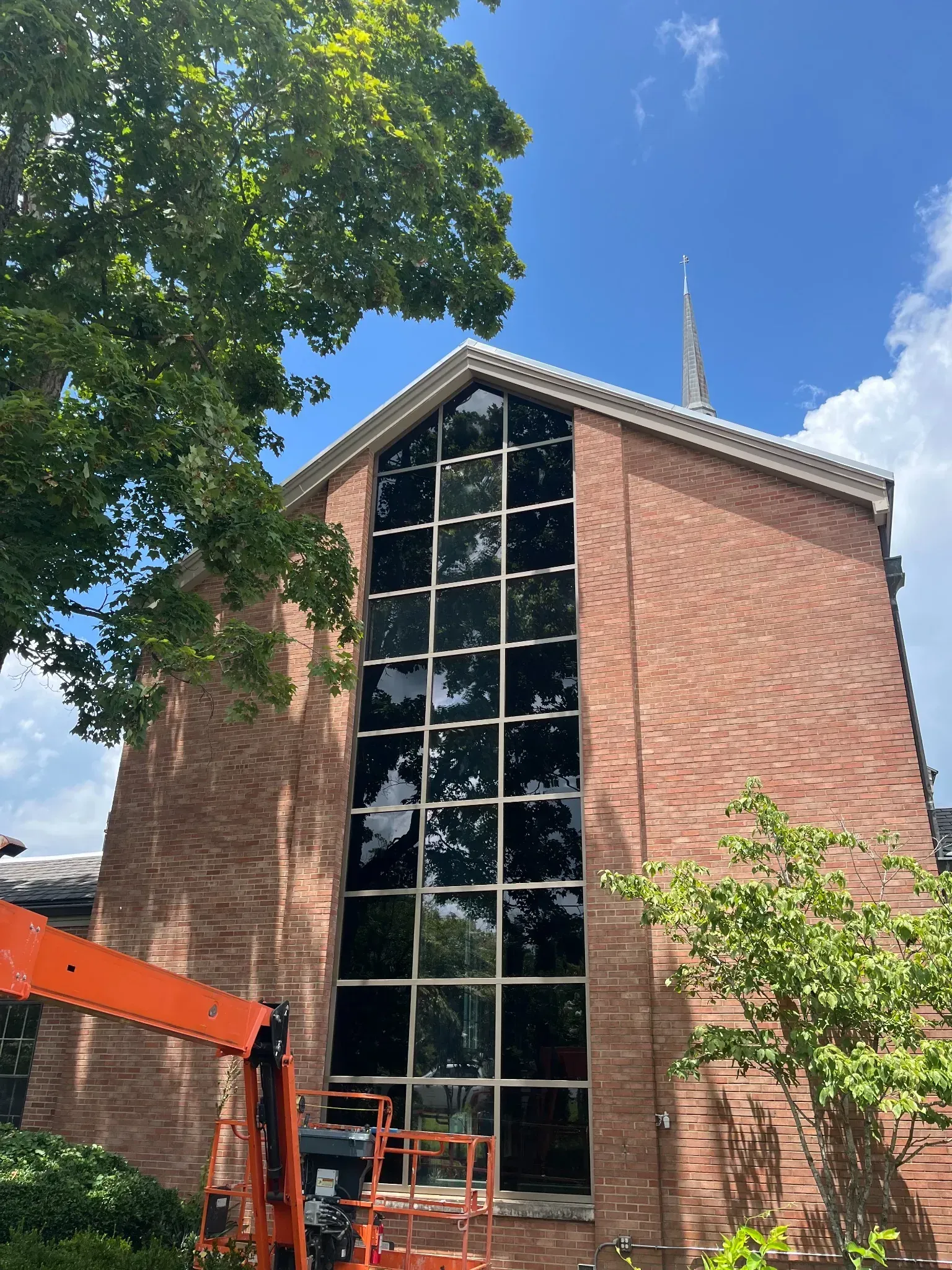 A large brick building with a lot of windows and a crane in front of it.