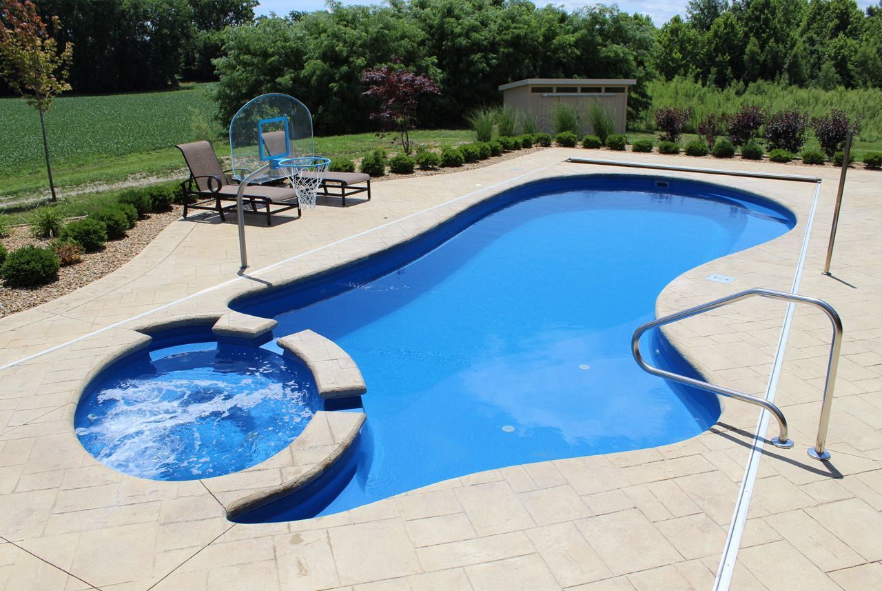 A large swimming pool with a jacuzzi in the middle