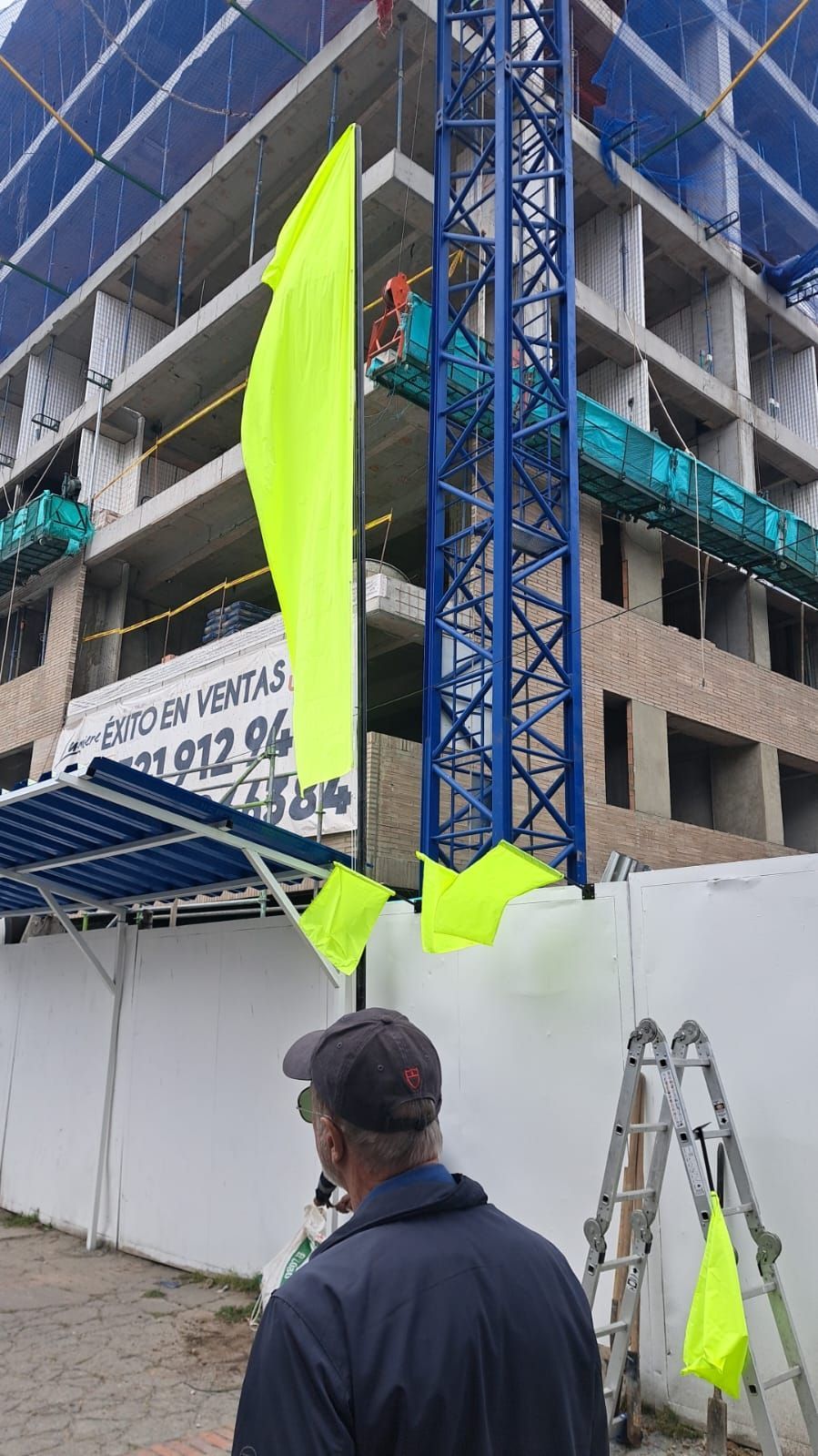 Un hombre está parado frente a un edificio en construcción.