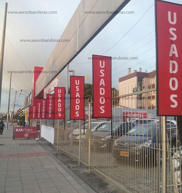 Una fila de carteles rojos de "usados" en una valla