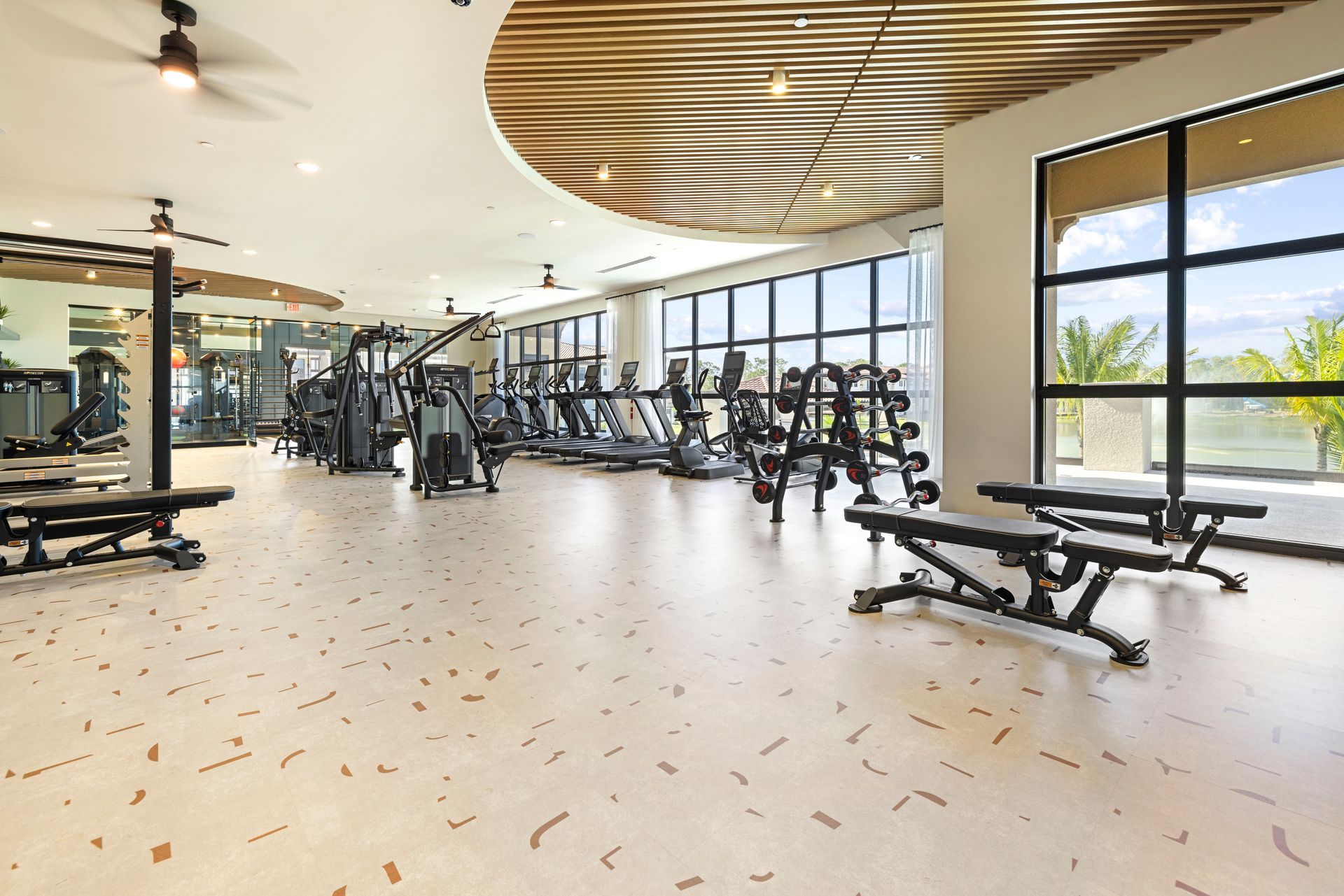 A large gym with a lot of exercise equipment and benches at Corsa at Estero Crossing.