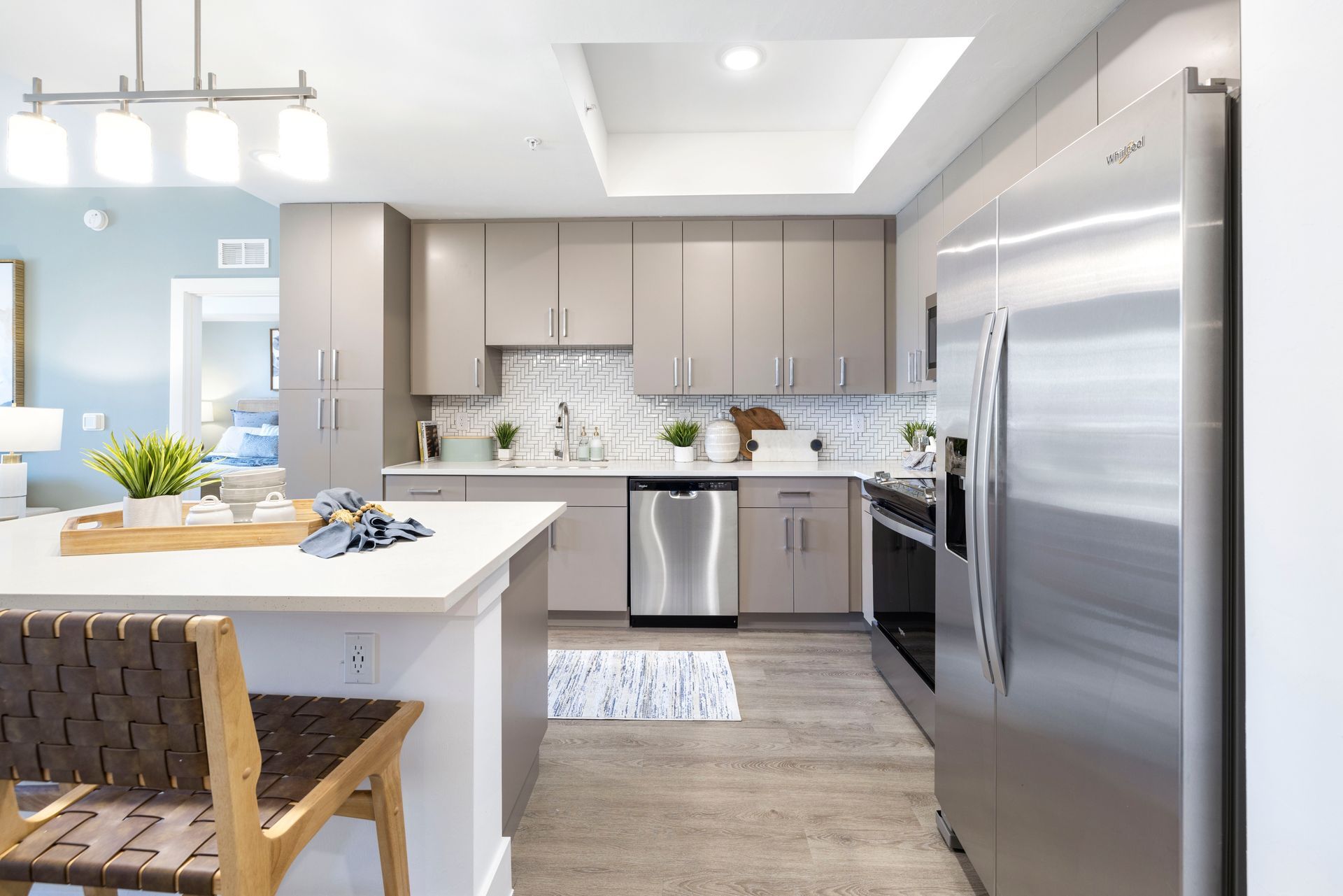 A kitchen with stainless steel appliances and gray cabinets at Corsa at Estero Crossing.