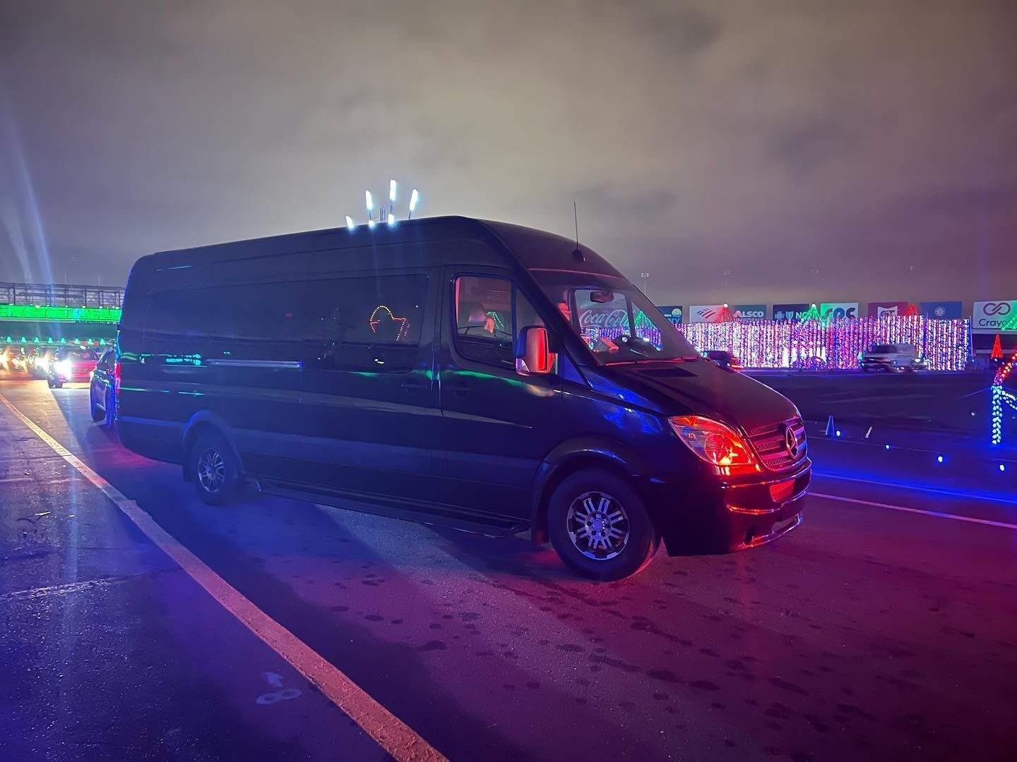 A black van is parked on the side of the road at night.