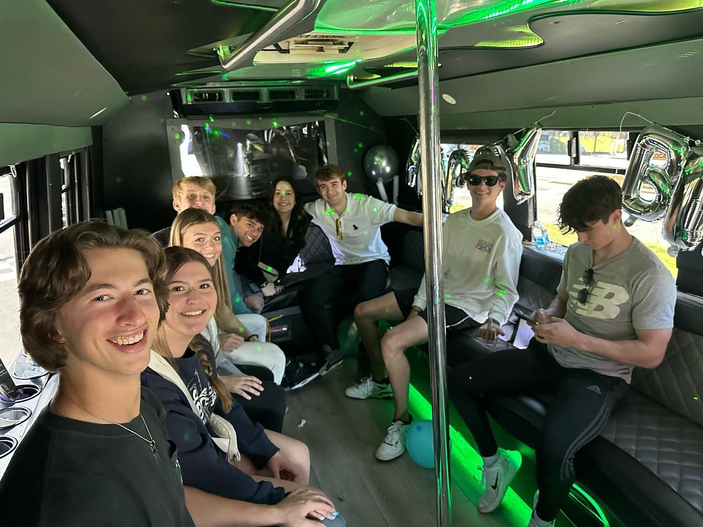 A group of young people are sitting in a party bus.