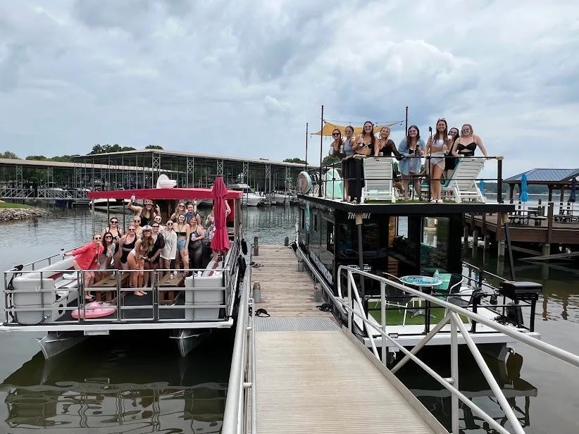 A group of people are standing on top of a boat at a dock.