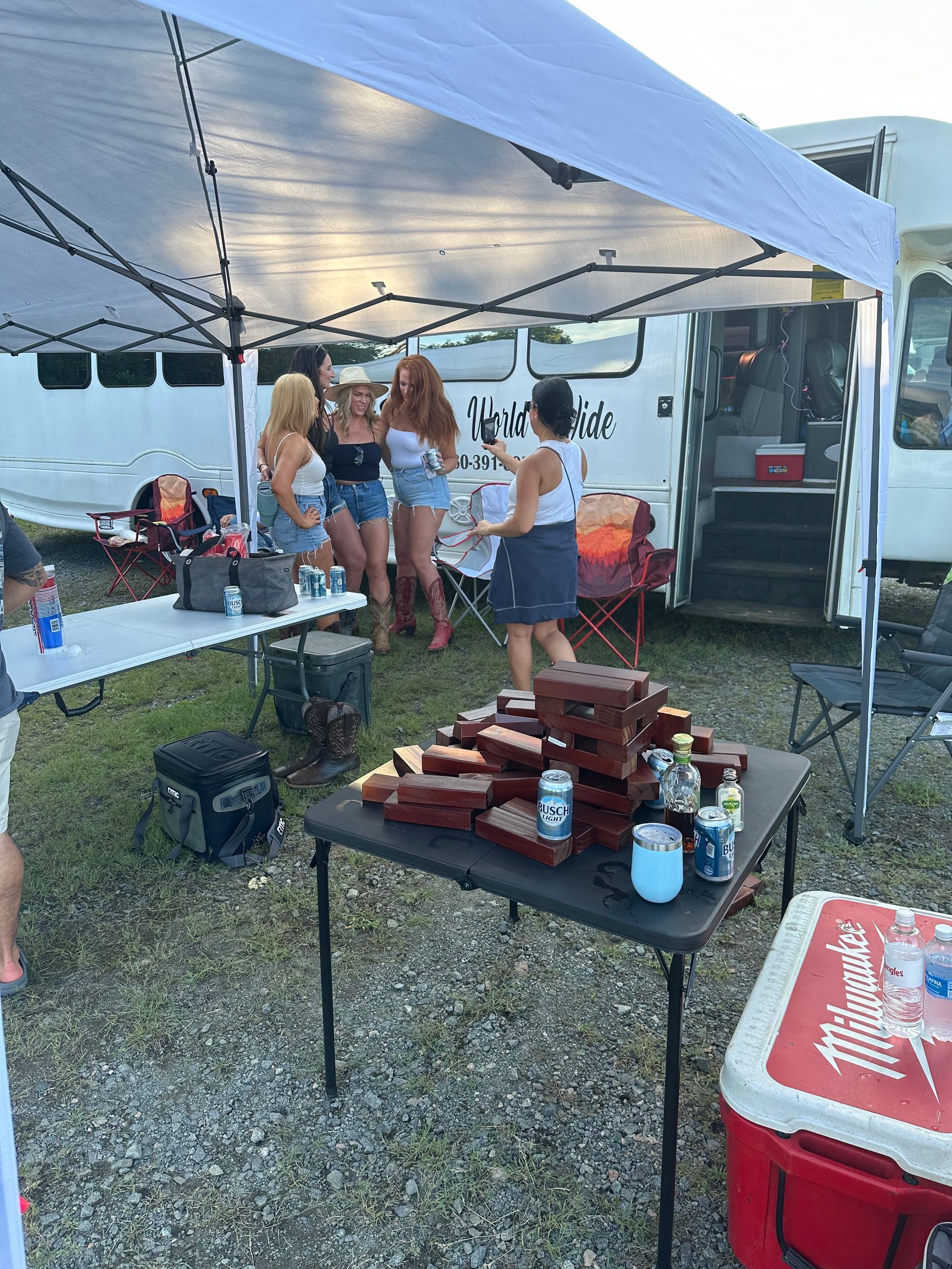 A group of people are standing around a table under a tent.
