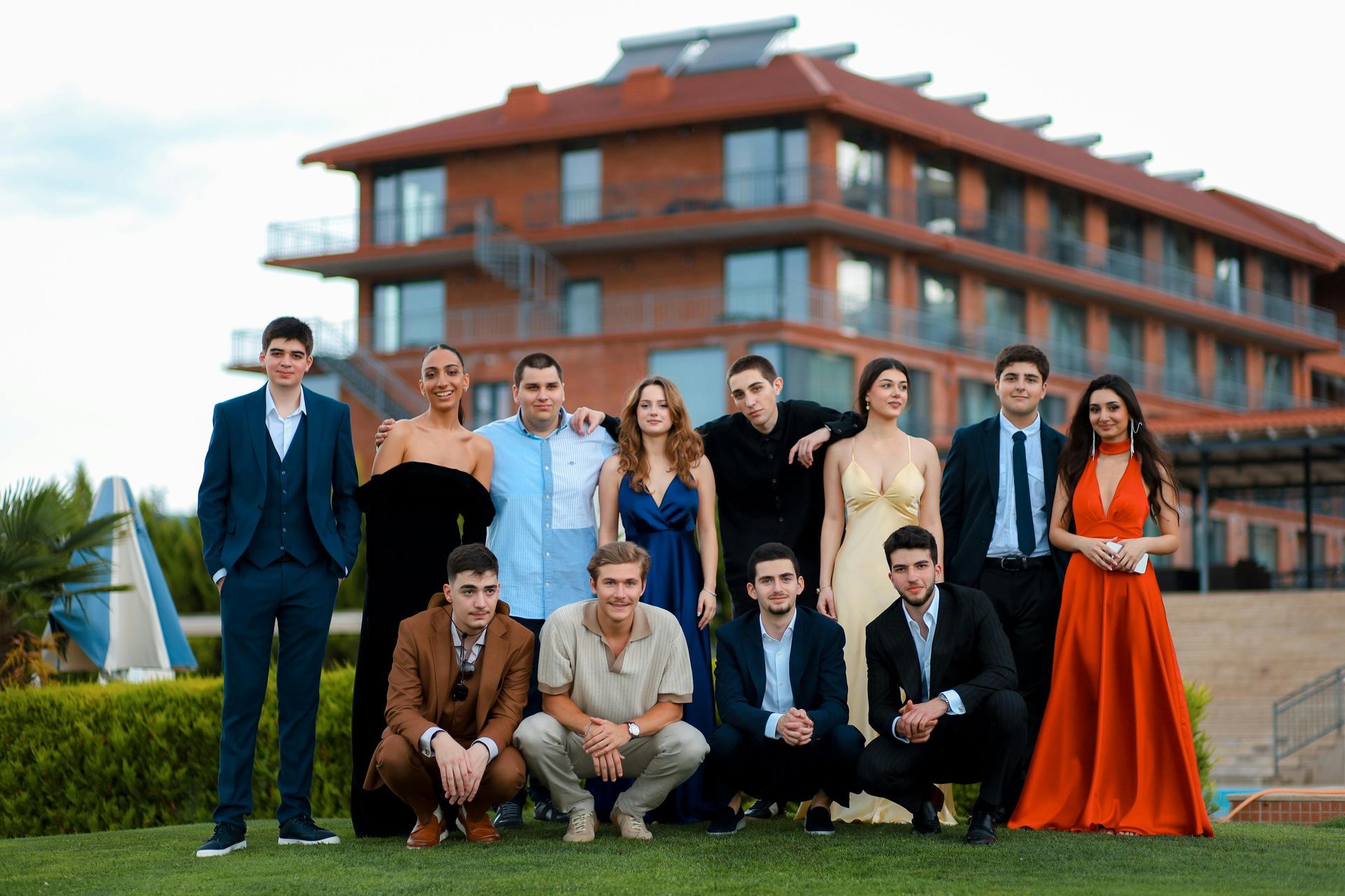 A group of people are posing for a picture in front of a large building.