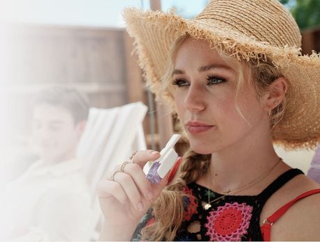 A woman using an Afrezza® Inhaler.