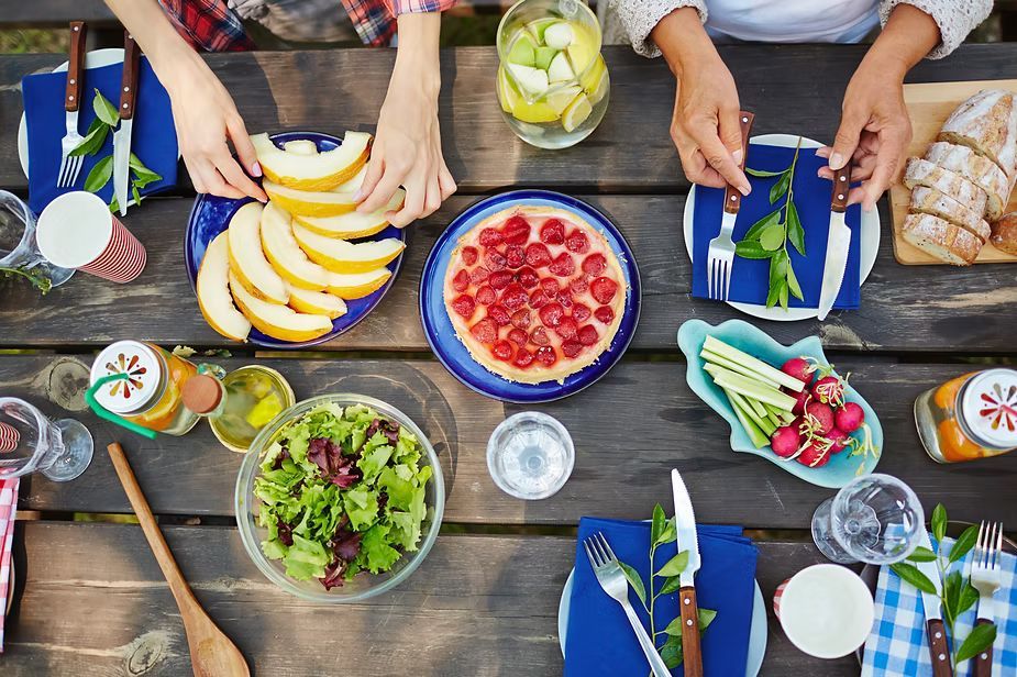A group of people eating at the park.