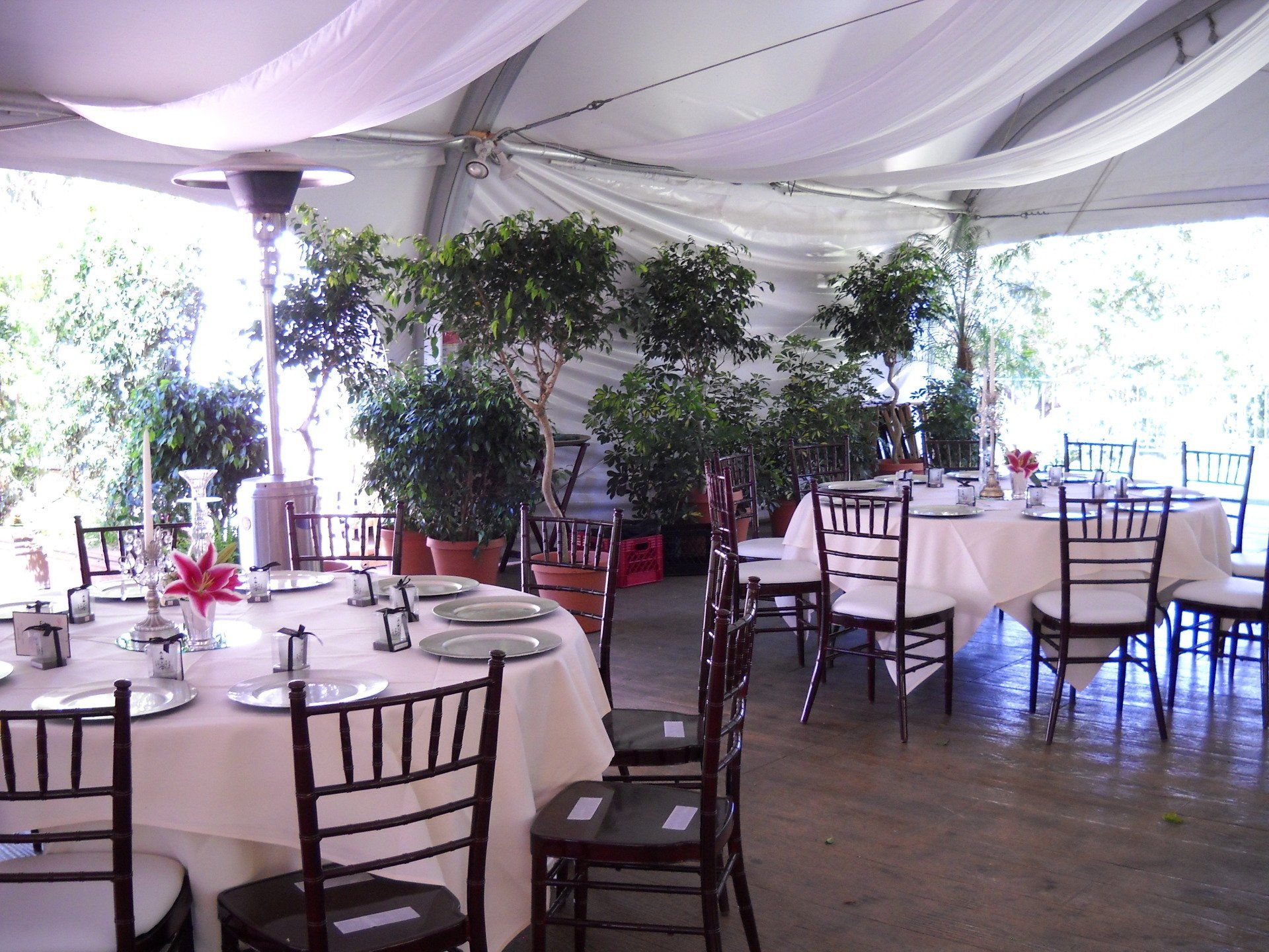 Tables and chairs are set up under a white tent