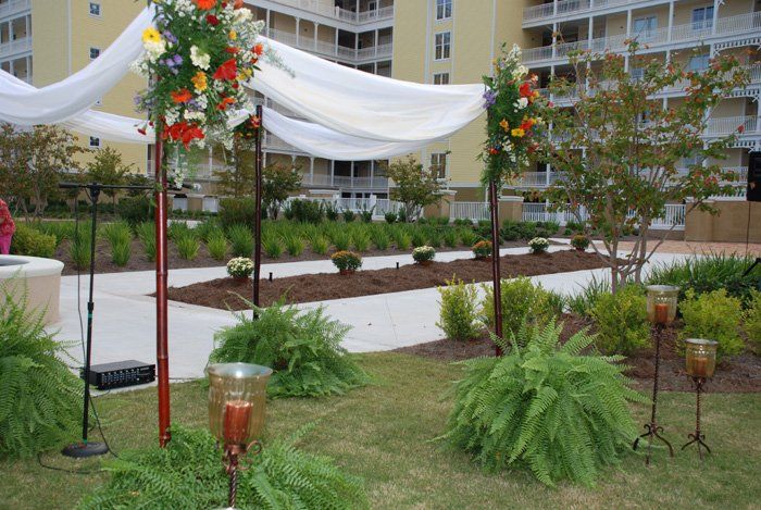 A garden with candles and flowers in front of a building