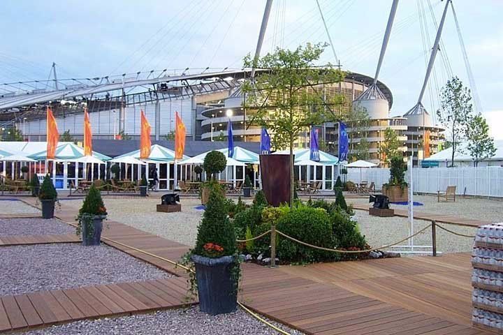 A stadium with a lot of umbrellas and trees in front of it