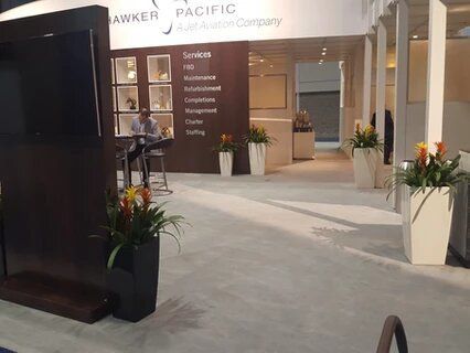 A man is sitting at a table in front of a sign that says lawker pacific