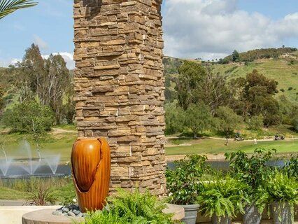 A stone pillar with a vase in front of it