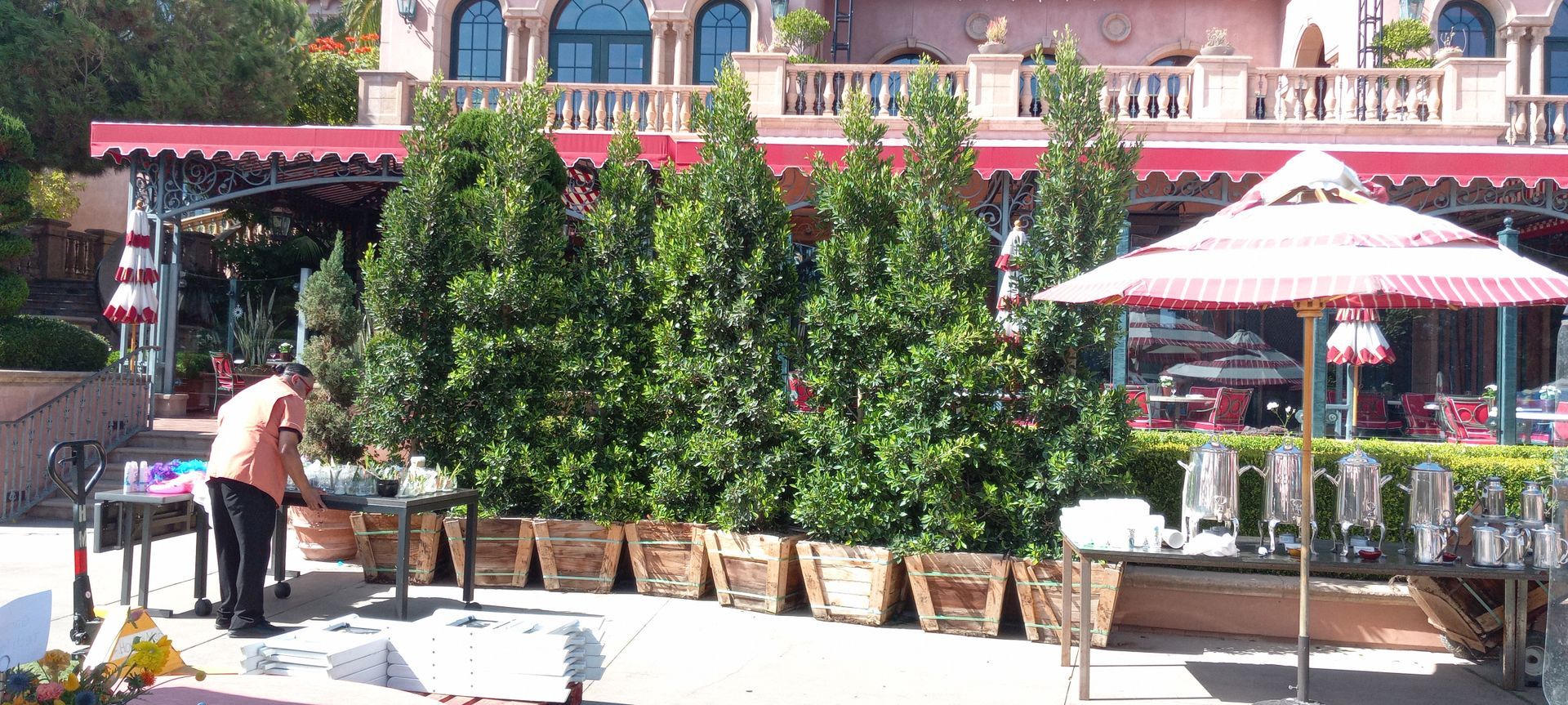 A man is standing in front of a building with a red awning