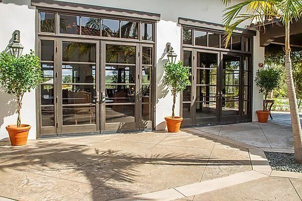A large building with a lot of windows and potted plants in front of it.