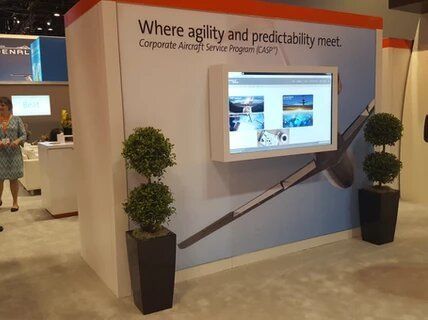 A woman stands in front of a display that says where agility and predictability meet