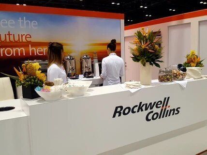 Two women standing behind a rockwell collins counter