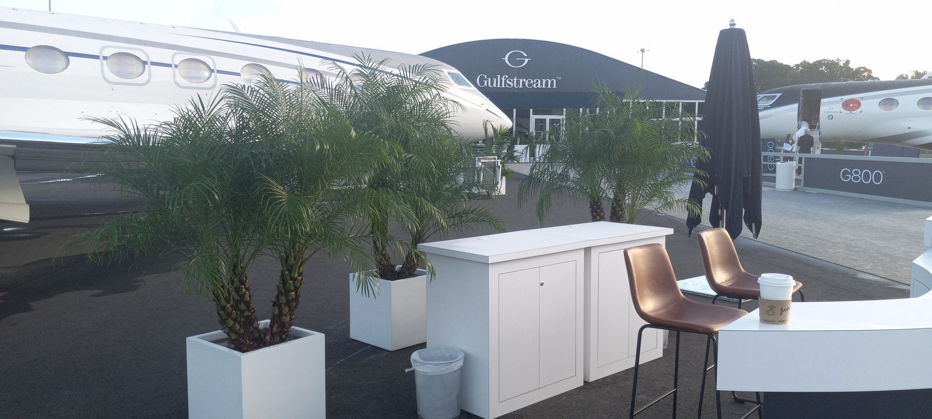 A table and chairs are sitting in front of a plane.