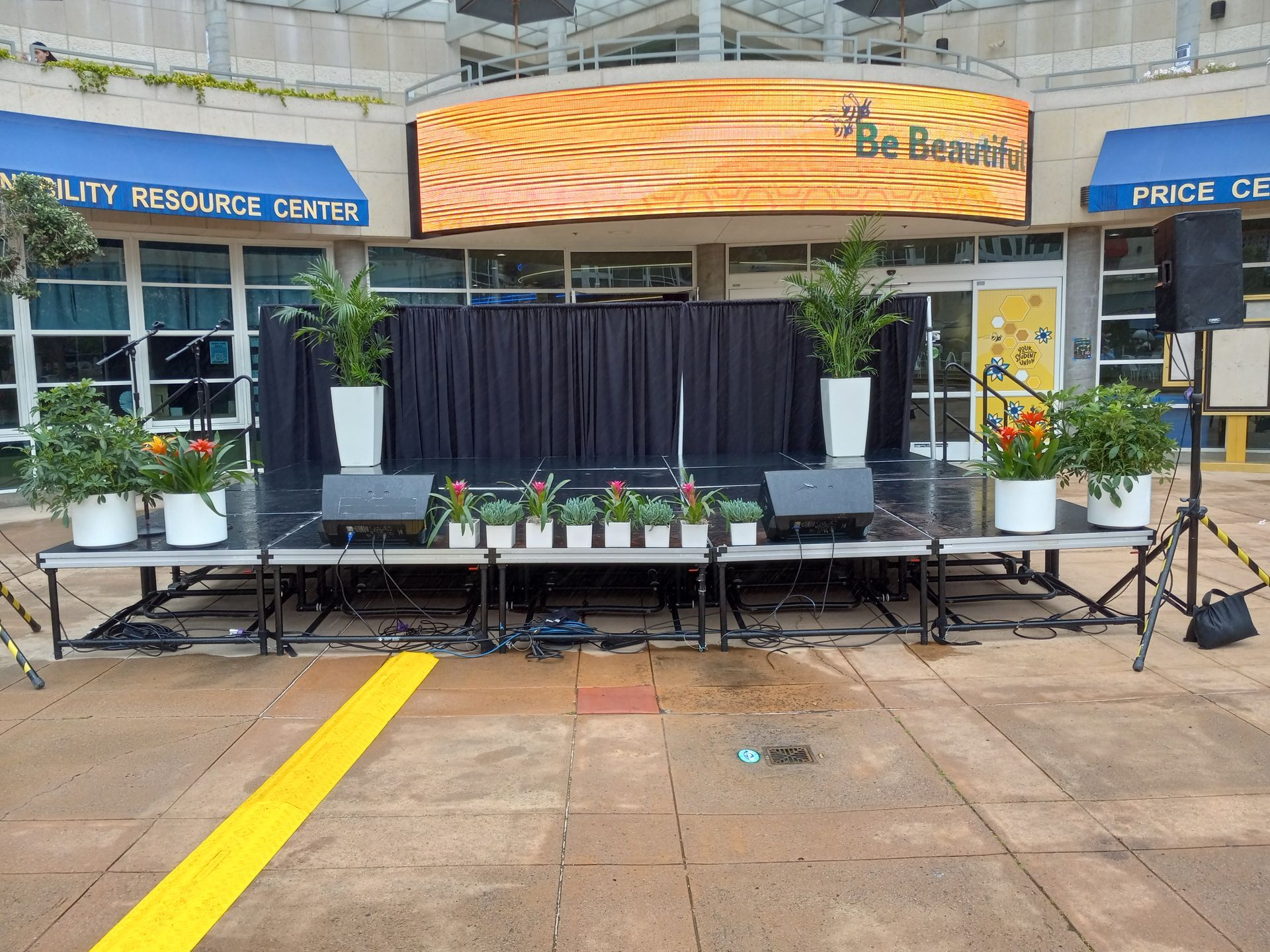 A stage in front of a building with a sign that says be beautiful