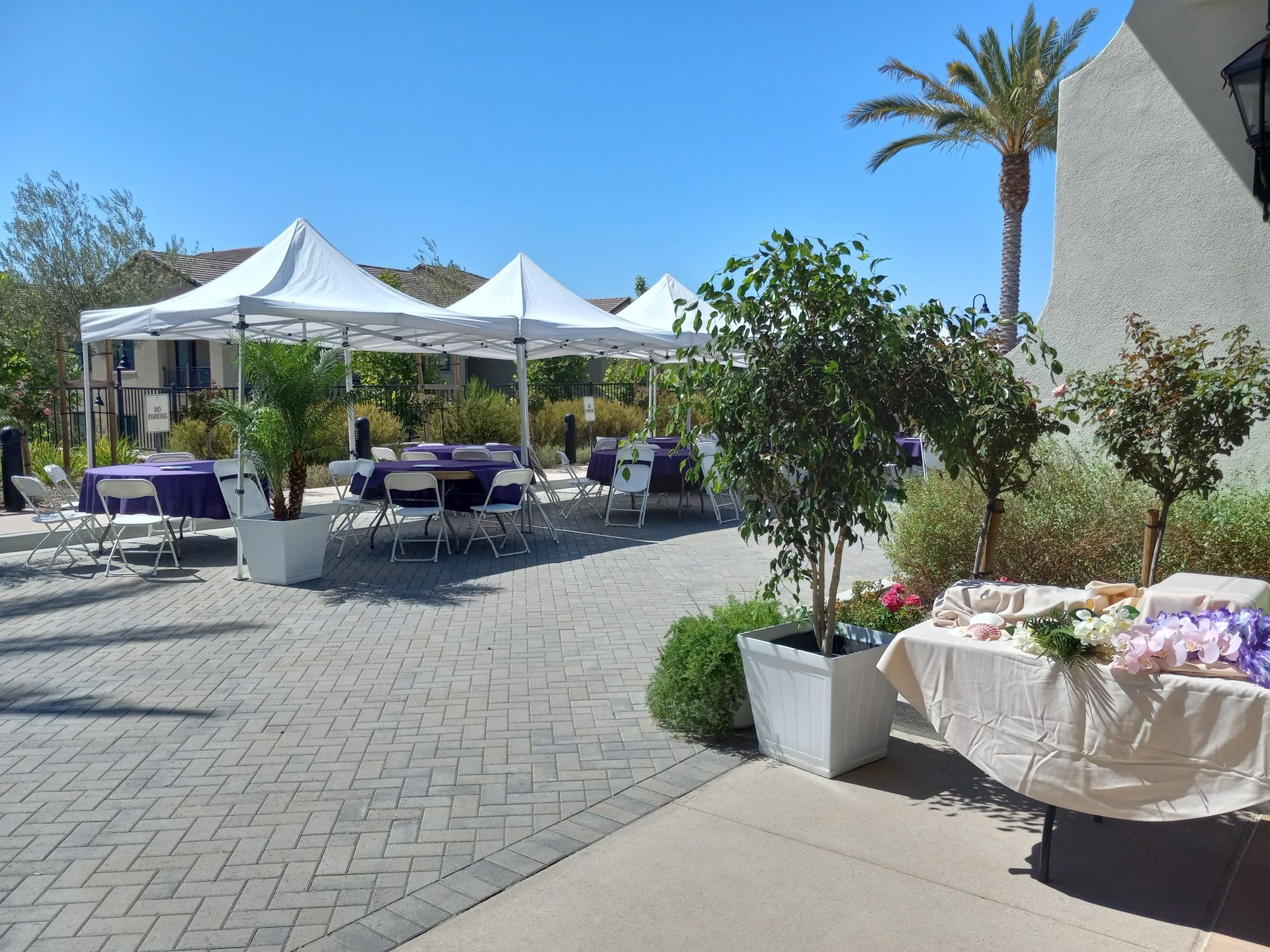 A patio with tables and chairs and a table with flowers on it