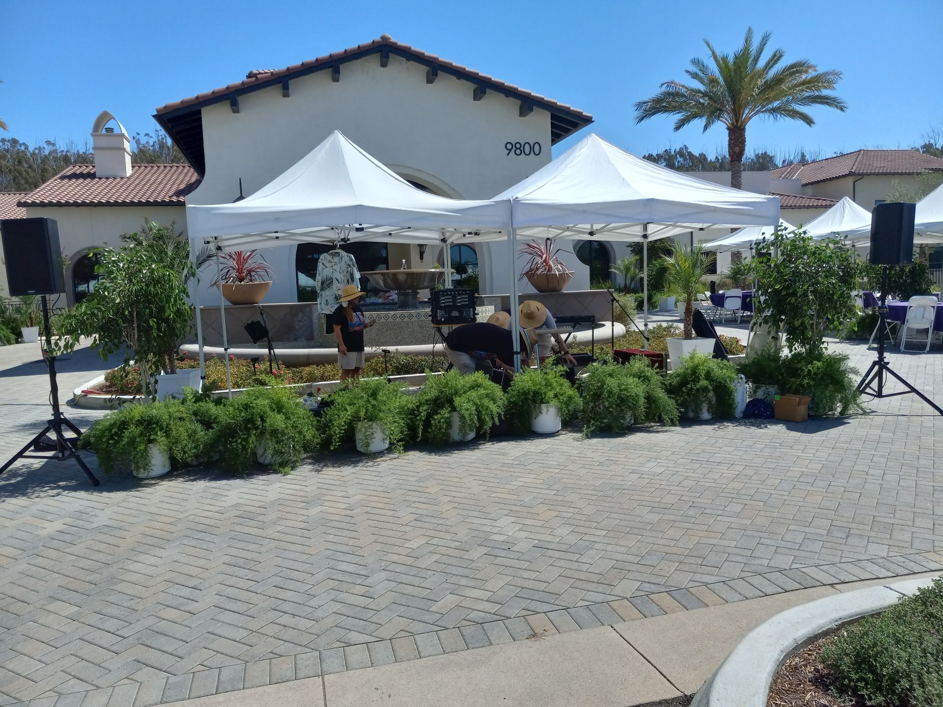 A group of white tents are set up in front of a building