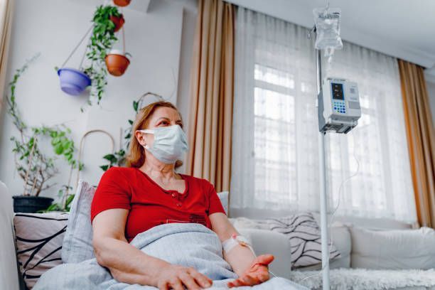 A Woman Wearing A Mask Is Sitting In A Hospital Bed - Morton Grove, IL - Orion Home Health (AKA Orion)