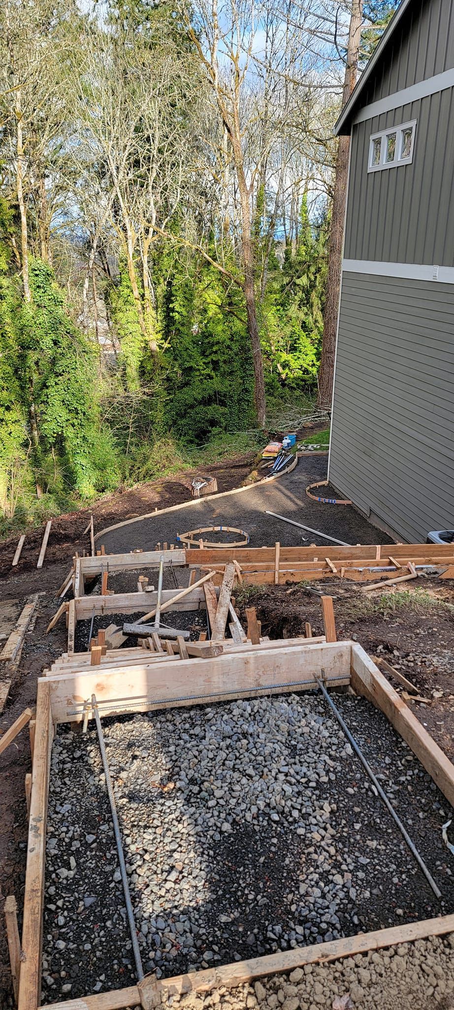 A concrete driveway is being built in front of a house.